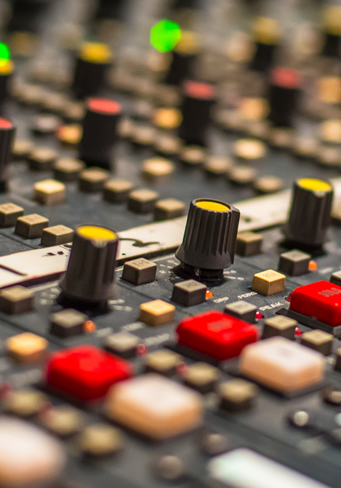 Close-up of knobs and buttons on a studio mixing console